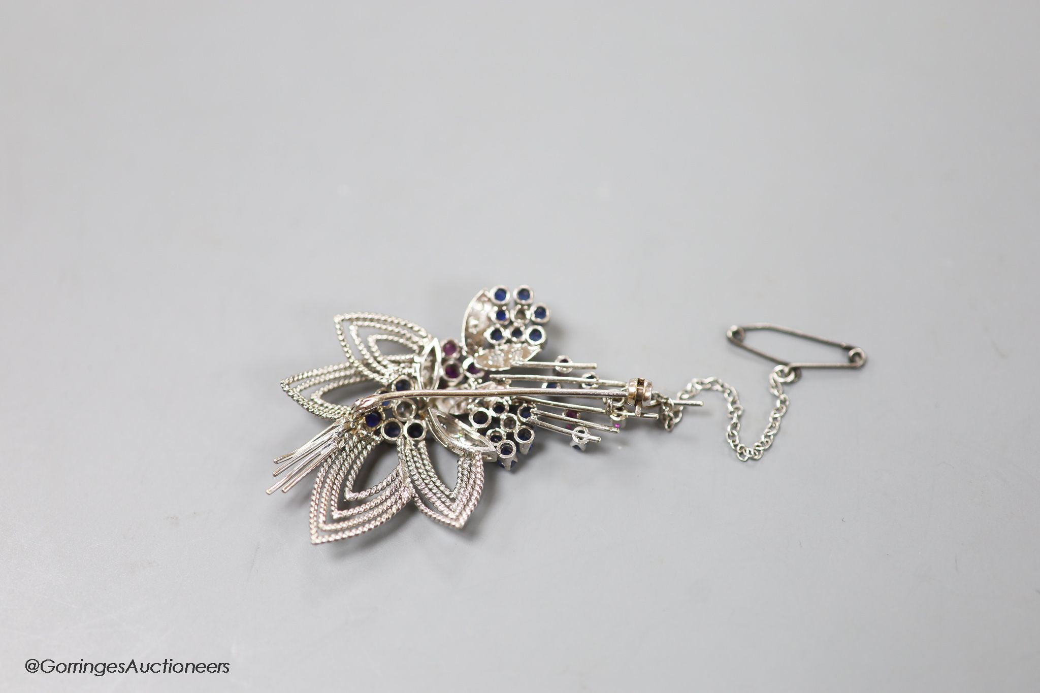 A modern white metal, ruby, sapphire and diamond set foliate spray brooch, 567mm